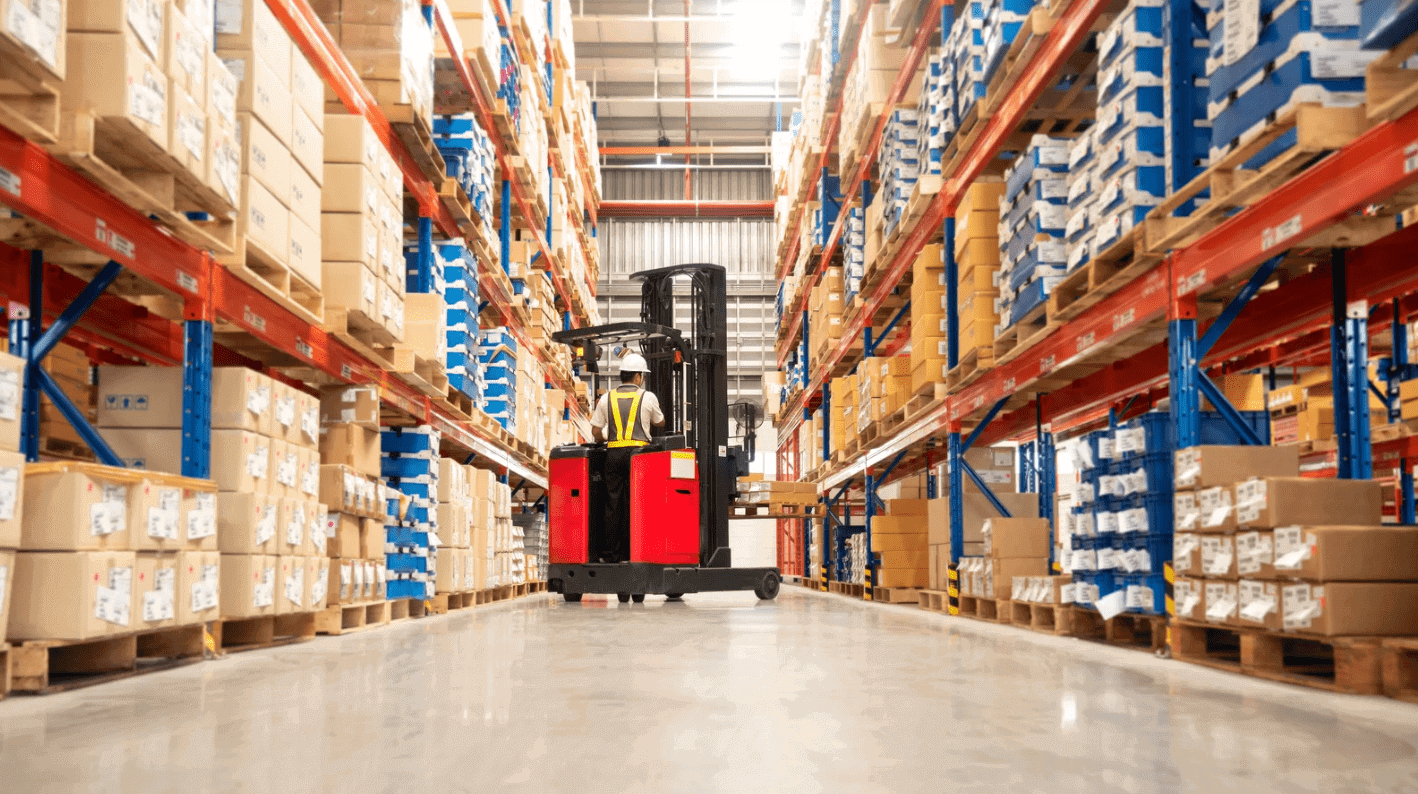 A warehouse employee efficiently using a computer amidst rows of inventory that highlights the importance of advanced cabling solutions for warehouse operations.