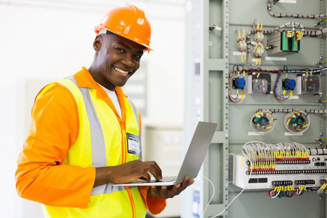 An IT engineer smiling whilst using a laptop as he has been hired using effective talent acquisition to help businesses navigate the IT skills gap